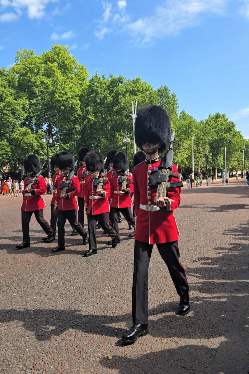 Guardias reales con gorros de piel de oso marchando por The Mall durante el cambio de guardia en Londres